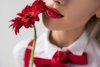 104729603-close-up-of-tendre-fille-avec-rouge-à-lèvres-et-fleur-de-gerbera-rouge-isolé-sur-...jpg